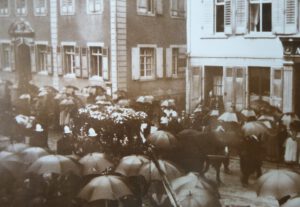 Begräbniszug Marcus Pflügers durch die Basler Straße im September 1907, begleitet von der Freiwilligen Feuerwehr, die er gründete und deren erster Kommandant er bis 1871 war, Stadtarchiv Lörrach 